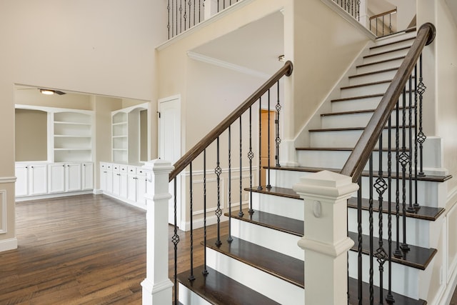 stairway with a high ceiling and hardwood / wood-style floors