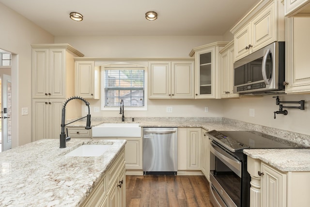 kitchen with dark hardwood / wood-style floors, sink, stainless steel appliances, and cream cabinets