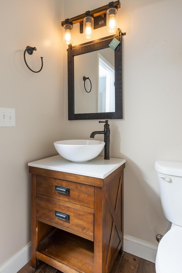 bathroom with vanity, toilet, and wood-type flooring