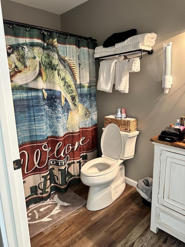 bathroom with toilet, hardwood / wood-style floors, and a shower with shower curtain