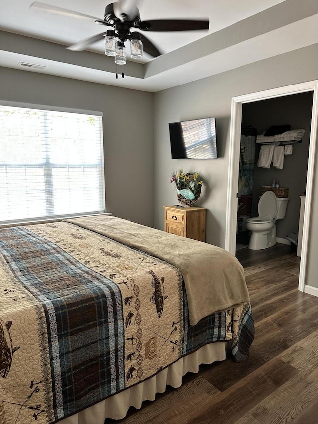 bedroom with ceiling fan, dark hardwood / wood-style flooring, and ensuite bath