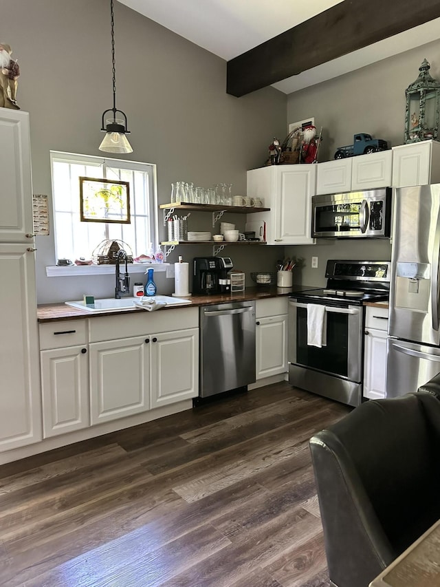 kitchen featuring white cabinetry, stainless steel appliances, dark wood-type flooring, and pendant lighting