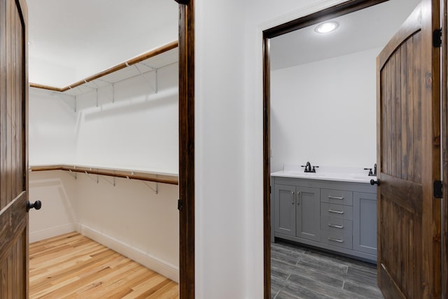 spacious closet featuring wood-type flooring and sink