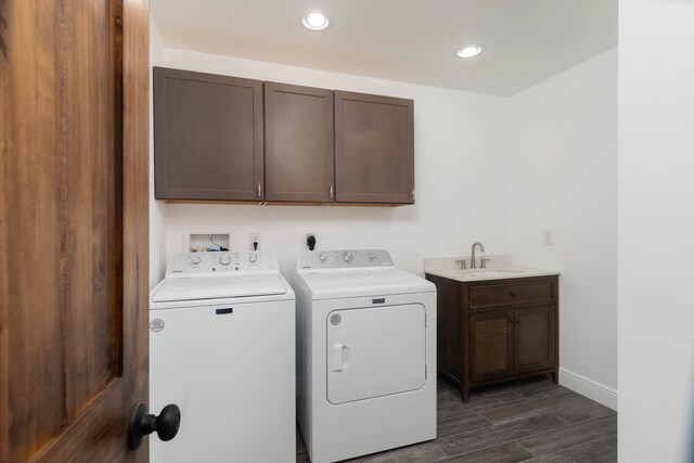 clothes washing area with separate washer and dryer, cabinets, dark hardwood / wood-style floors, and sink