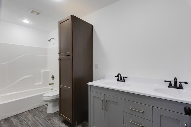 full bathroom featuring vanity, hardwood / wood-style floors, toilet, and bathtub / shower combination