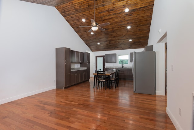 kitchen featuring high vaulted ceiling, dark hardwood / wood-style flooring, ceiling fan, and stainless steel refrigerator