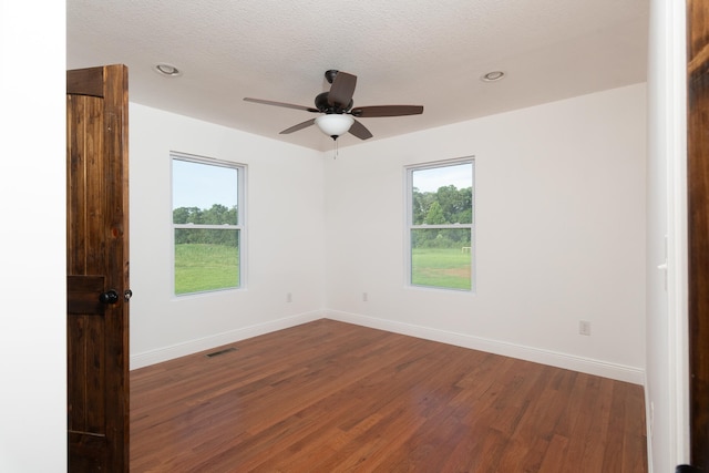 spare room featuring ceiling fan, dark wood-type flooring, and a textured ceiling