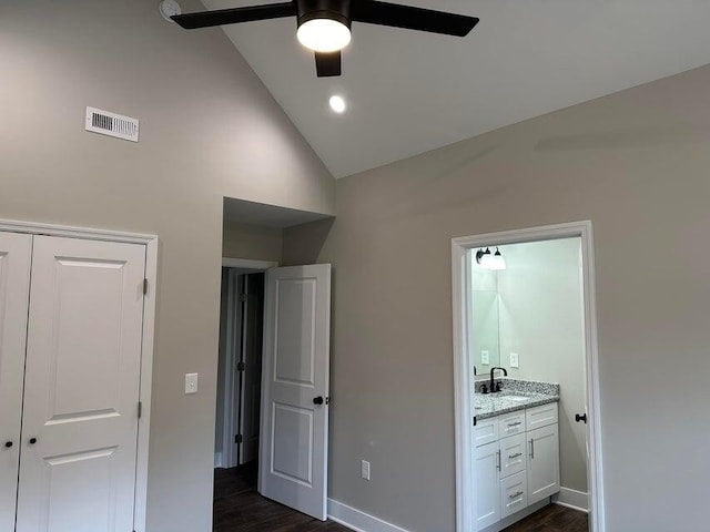 unfurnished bedroom with ceiling fan, sink, high vaulted ceiling, and dark wood-type flooring