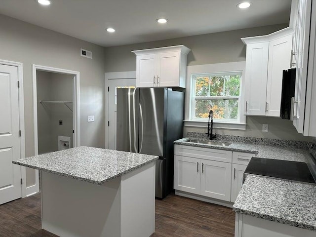 kitchen featuring a center island, sink, and white cabinets