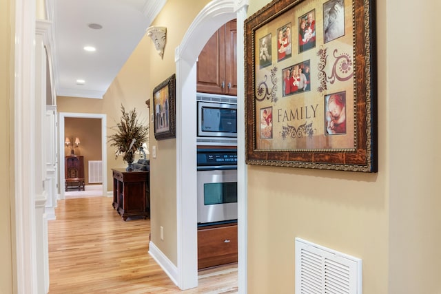 hall featuring crown molding and light hardwood / wood-style floors