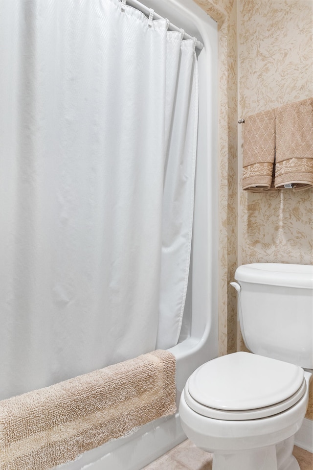 bathroom featuring toilet, shower / bathtub combination with curtain, and tile patterned floors