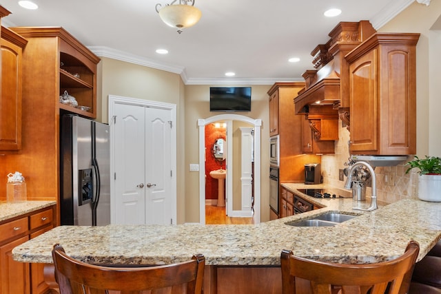 kitchen featuring appliances with stainless steel finishes, kitchen peninsula, and a breakfast bar area