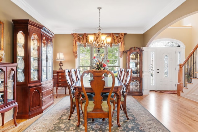 dining area with a notable chandelier, light hardwood / wood-style flooring, and ornamental molding