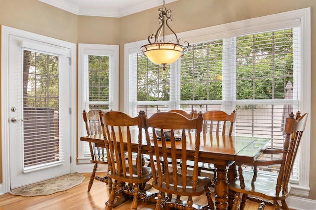 dining area with ornamental molding and hardwood / wood-style flooring