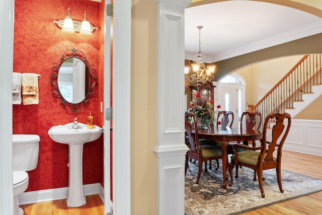 dining space featuring a healthy amount of sunlight, crown molding, hardwood / wood-style floors, and a notable chandelier