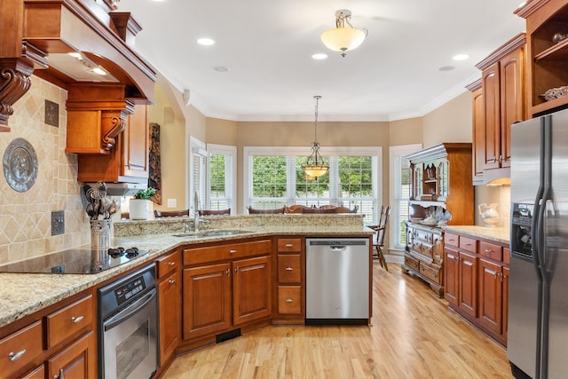 kitchen with pendant lighting, sink, light hardwood / wood-style flooring, appliances with stainless steel finishes, and crown molding