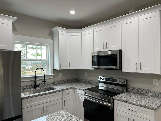 1342 Unity Dr NE Lot 19B, Cleveland, TN 37312 - kitchen with appliances with stainless steel finishes, a sink, white cabinets, recessed lighting, and light stone counters