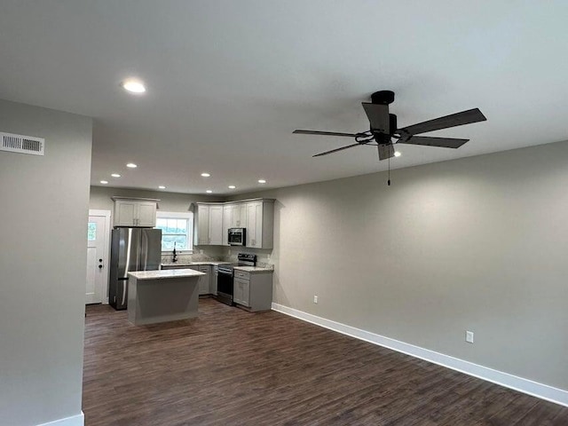 kitchen featuring appliances with stainless steel finishes, gray cabinetry, ceiling fan, dark wood-type flooring, and a kitchen island