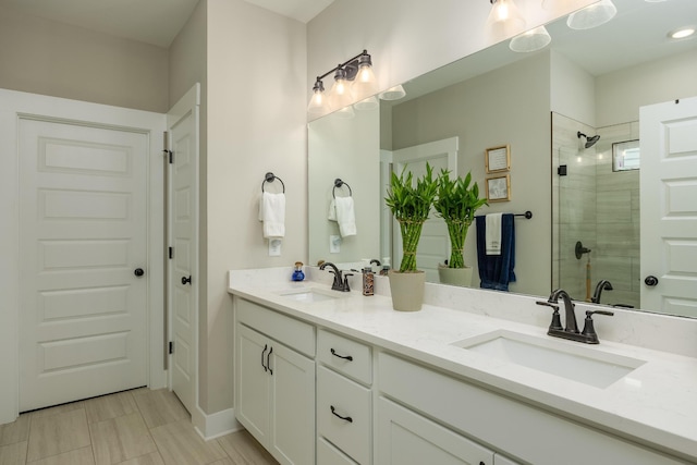 bathroom with a tile shower and vanity