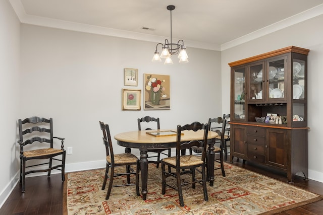 dining room featuring ornamental molding, an inviting chandelier, and dark wood-type flooring