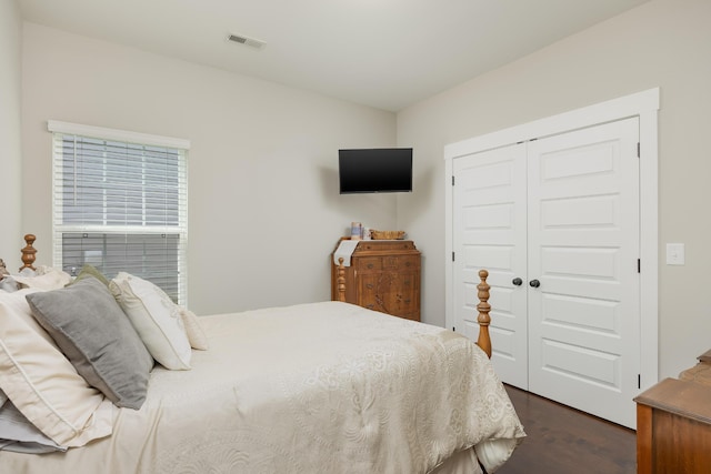 bedroom with dark wood-type flooring and a closet