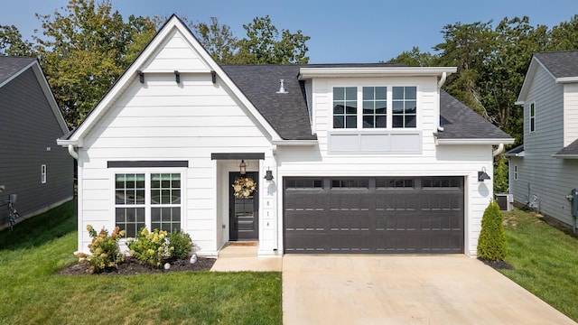 view of front of home featuring a front lawn, central air condition unit, and a garage