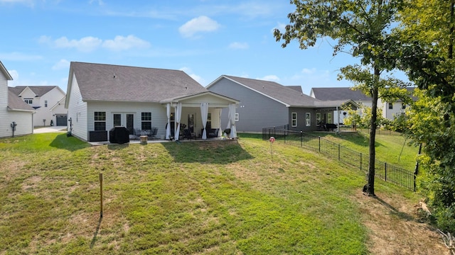 rear view of property featuring a yard and a patio area