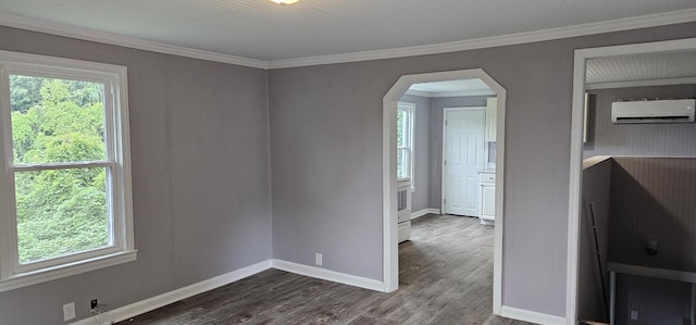 empty room featuring ornamental molding, a wall unit AC, and dark wood-type flooring