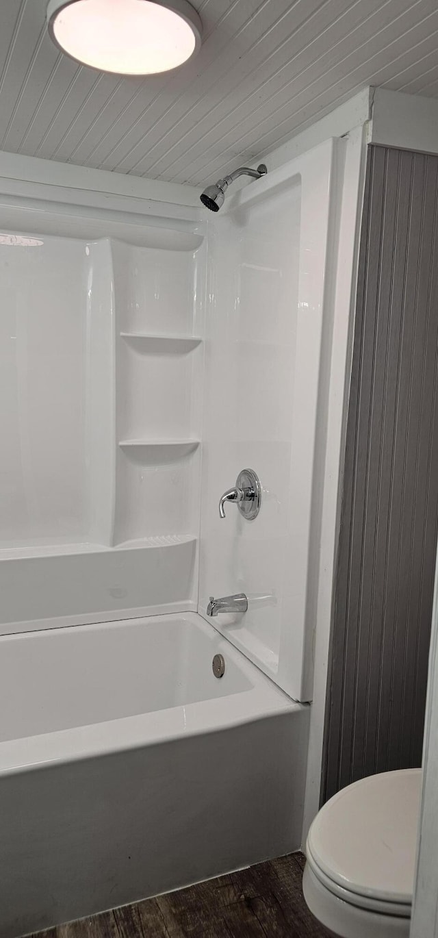 bathroom with shower / tub combination, hardwood / wood-style floors, and toilet