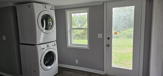 washroom featuring stacked washing maching and dryer and dark wood-type flooring