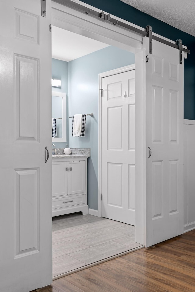 bathroom with vanity, hardwood / wood-style floors, and a textured ceiling