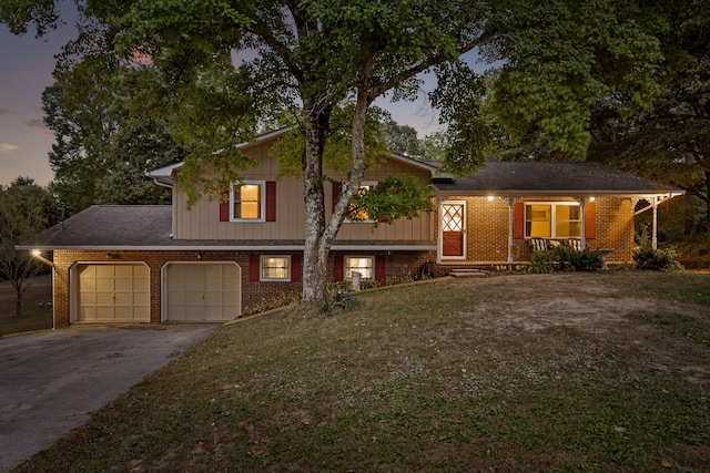 split level home featuring a garage and a lawn