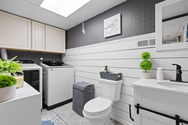 bathroom featuring vanity, tile patterned flooring, a drop ceiling, toilet, and washer and dryer