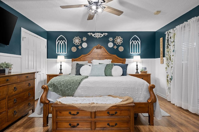 bedroom featuring a closet, ceiling fan, hardwood / wood-style floors, and a textured ceiling