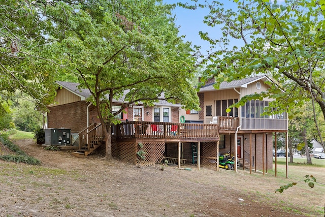 rear view of house featuring a wooden deck and a sunroom