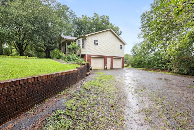 view of side of home featuring a garage and a lawn