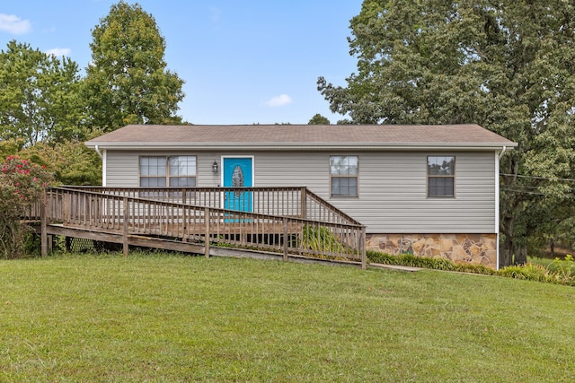 rear view of property with a yard and a wooden deck