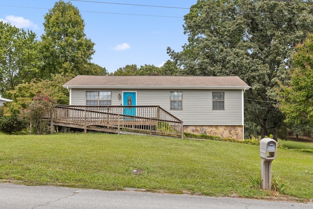 view of front facade featuring a front lawn and a wooden deck