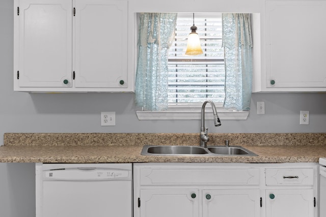 kitchen with white dishwasher, sink, and white cabinetry