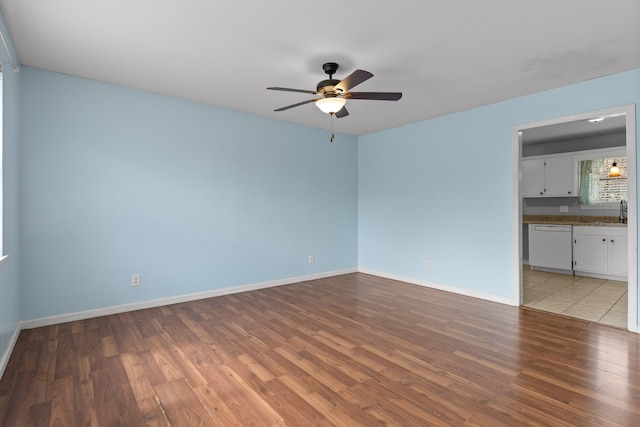 spare room with ceiling fan, light wood-type flooring, and sink