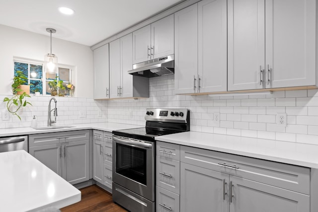 kitchen featuring sink, tasteful backsplash, dark wood-type flooring, gray cabinets, and appliances with stainless steel finishes