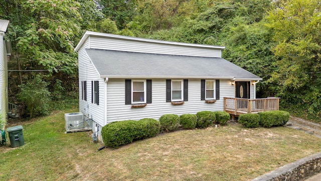 view of front of house with central AC unit, a wooden deck, and a front lawn