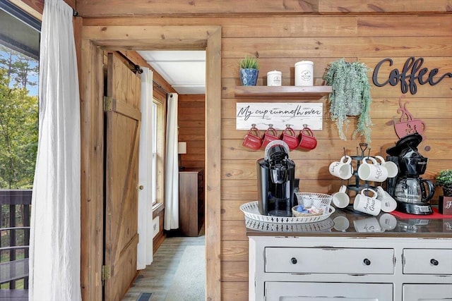 interior space featuring light wood-type flooring, wood walls, and white cabinetry