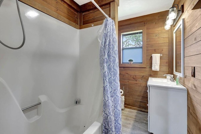 bathroom featuring vanity, wood walls, hardwood / wood-style flooring, and shower / tub combo with curtain