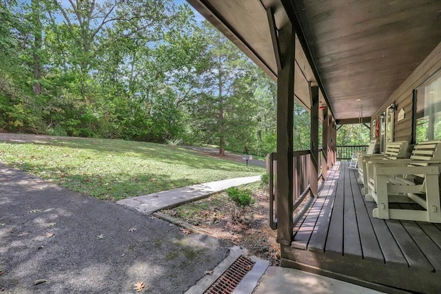 deck featuring covered porch and a yard