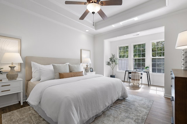 bedroom with a tray ceiling, ceiling fan, hardwood / wood-style floors, and crown molding