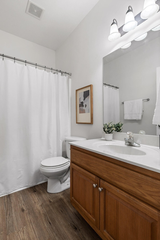 bathroom featuring wood-type flooring, vanity, and toilet