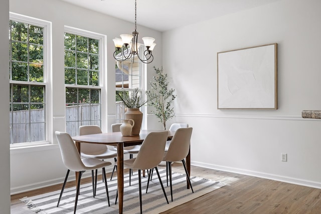 dining room with hardwood / wood-style flooring and a chandelier