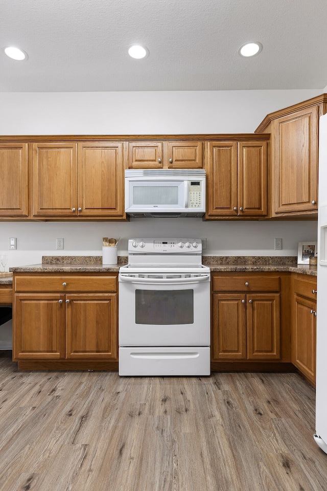 kitchen featuring light wood-type flooring and white appliances