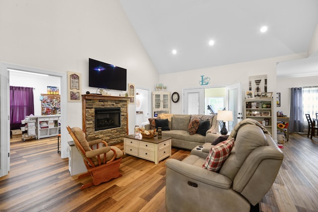 living room with high vaulted ceiling, wood-type flooring, and a fireplace